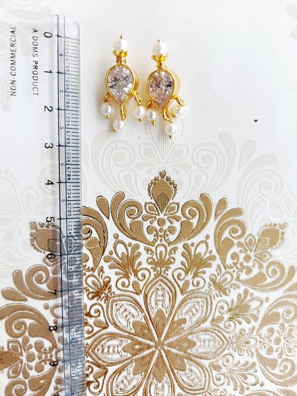 Elegant white stone earrings with intricate golden floral design from Mugdha Jewellery Store