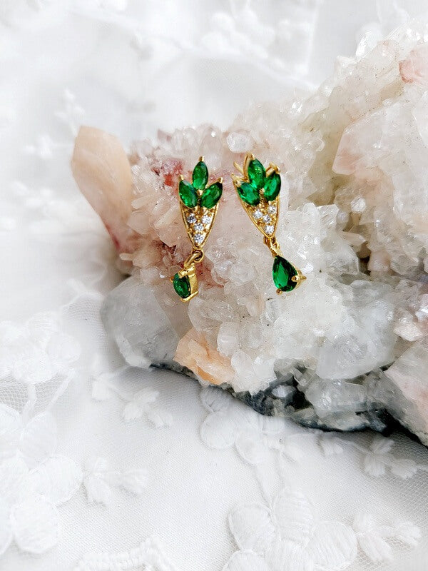 Elegant green stone flower basket earrings from Mugdha Jewellery Store, displayed against a natural crystal backdrop.