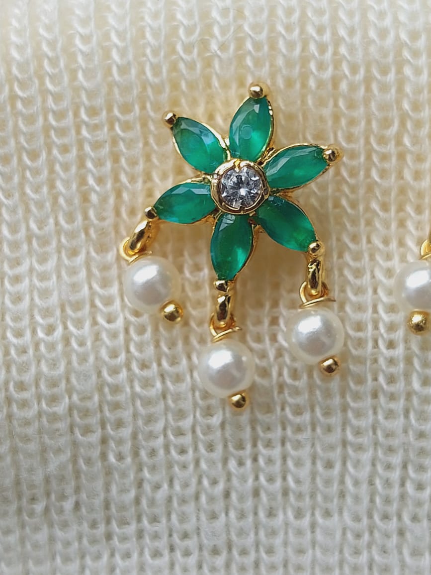 Green Stone Star Flower Stud Earrings with Pearls - Elegant floral earrings featuring emerald-colored stones arranged in a star-shaped design, accented with shimmering pearls, set in a metallic gold-toned frame.