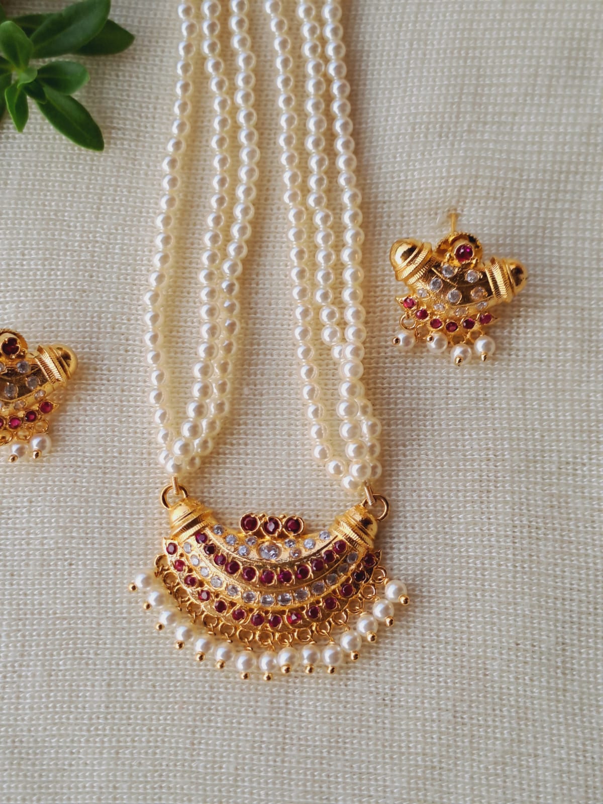 Rows of lustrous pearl beads, accented by ornate gold jewelry pieces with sparkling gemstones, create an elegant and refined necklace.