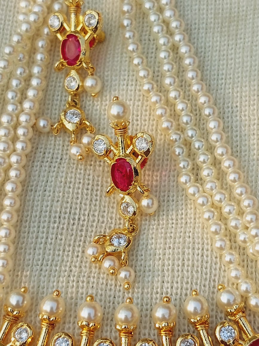 Elegant designer Maharani tanmani necklace with pearl strings and intricate gold-tone jewels featuring sparkling ruby stones and diamonds.