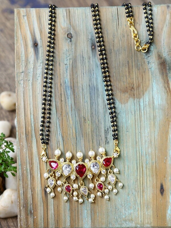 Red AD 5 Stone Puneri Tanmani Mangalsutra with Intricate Floral Pendant on Wooden Background