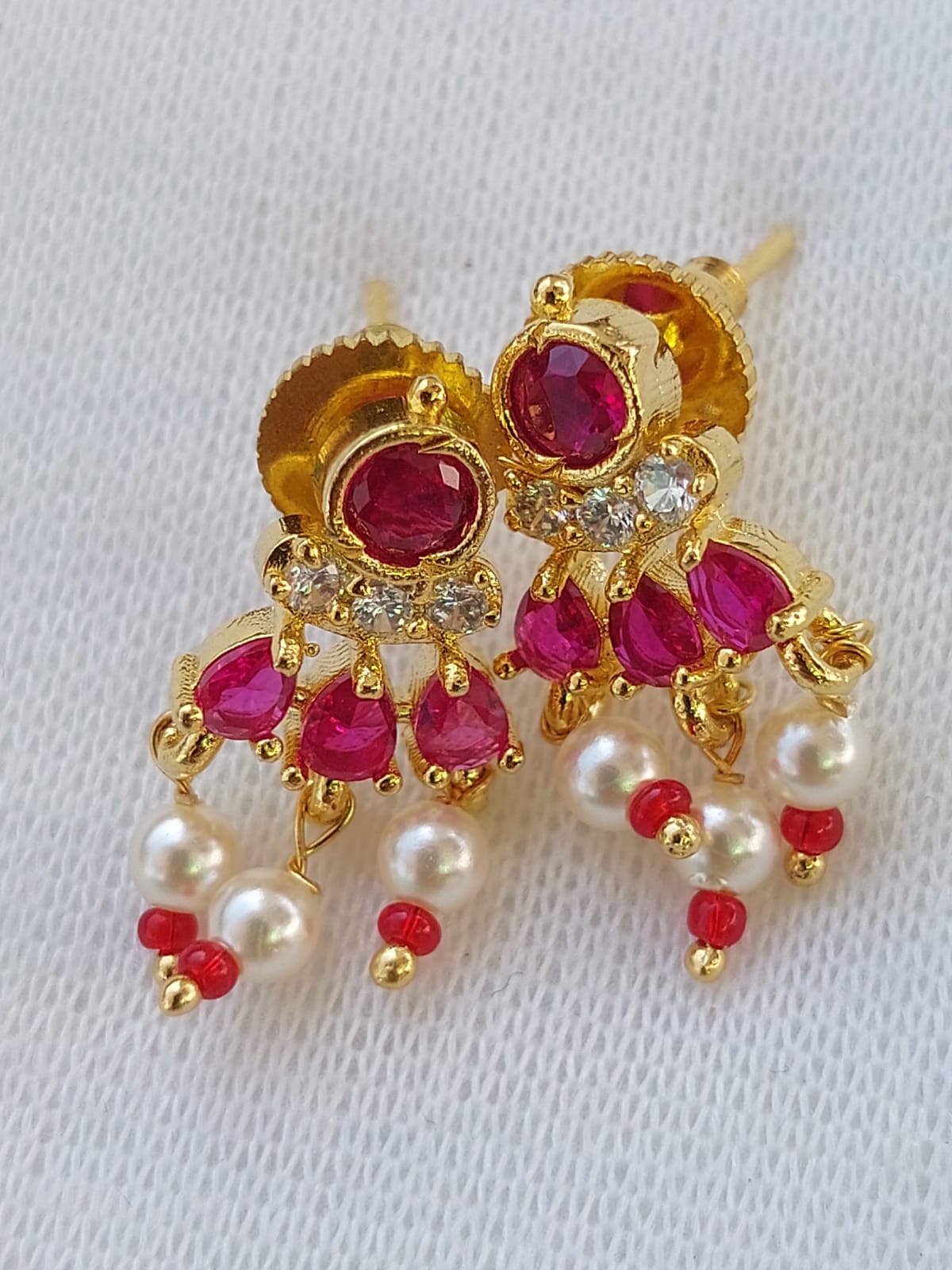 American Diamond Dark Pink Stone Fancy Tanmani Earrings from Mugdha Jewellery Store featuring intricate gold-toned design with red gemstones and pearl accents.