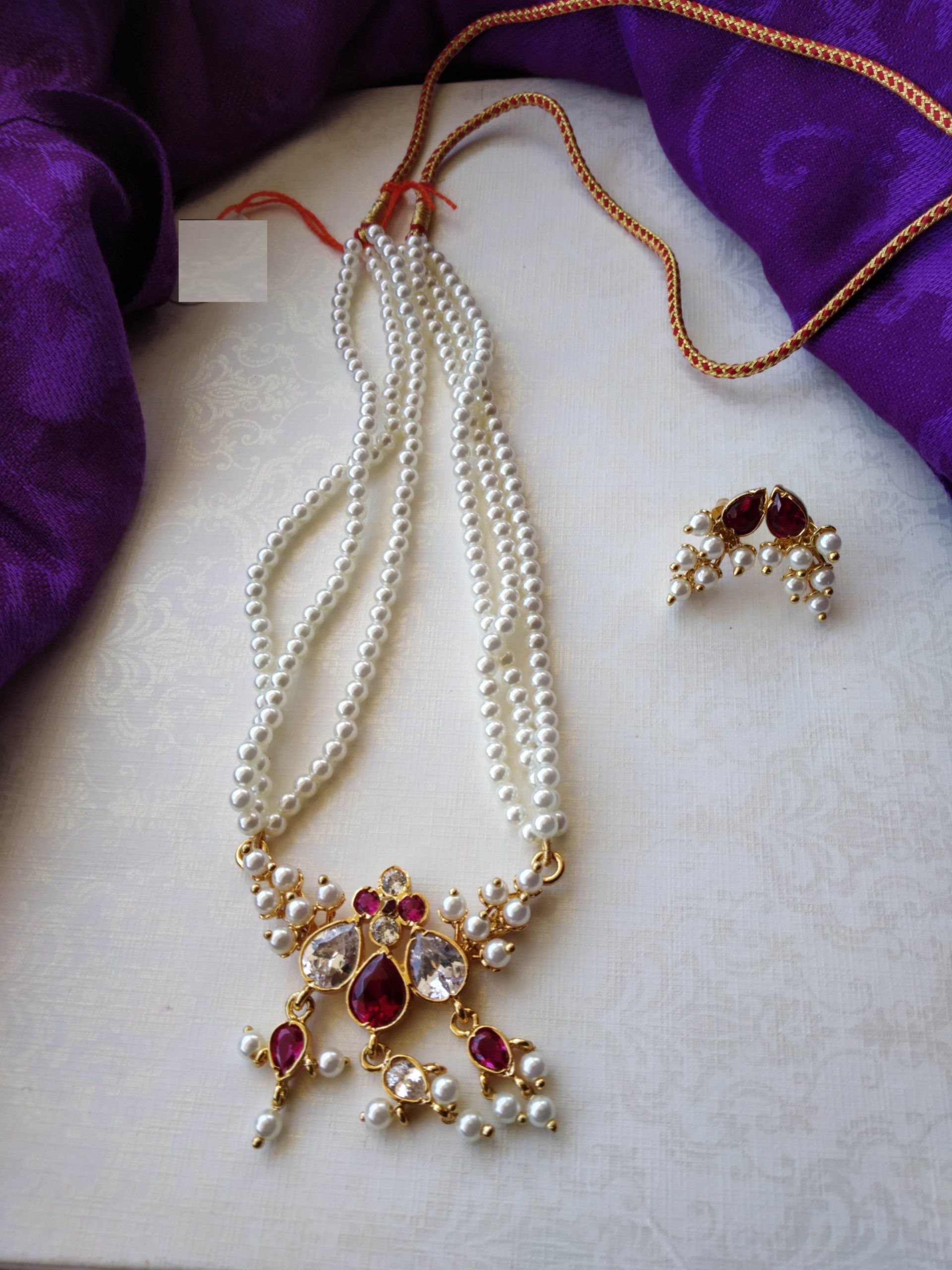 Elegant pearl necklace with vibrant red and gold gemstone pendant from Mugdha Jewellery Store