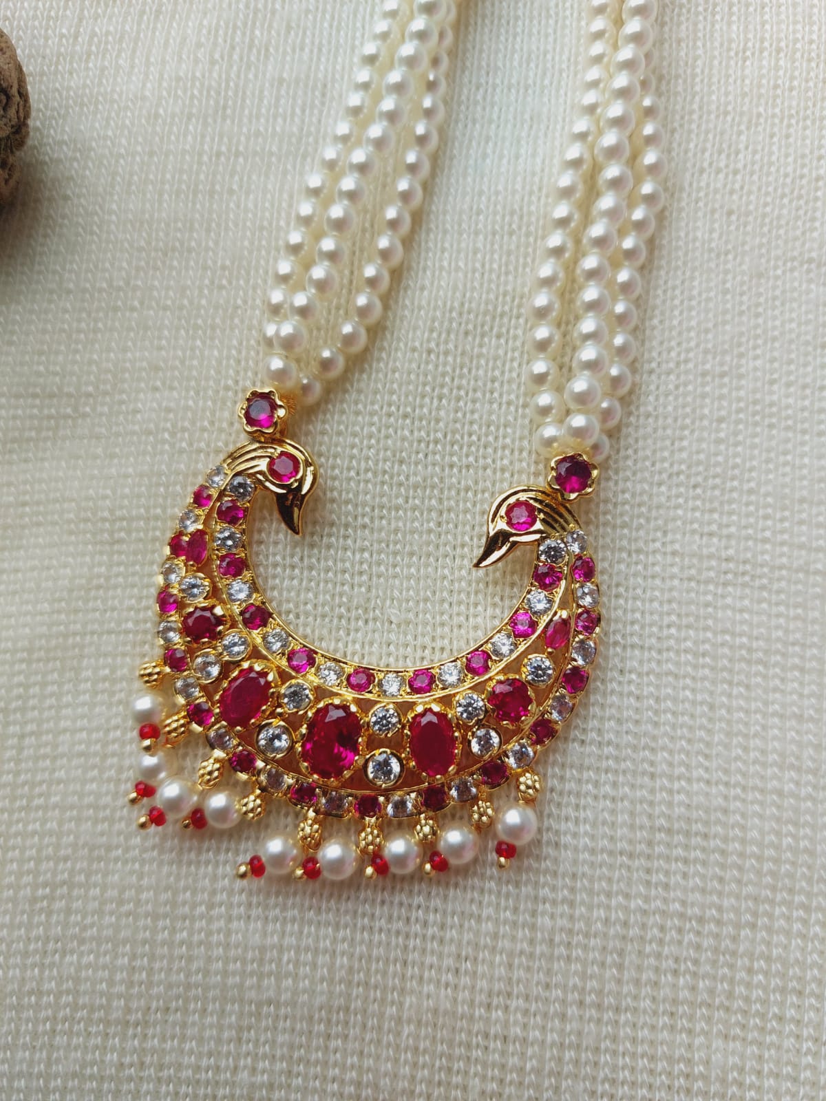 Elegant pearl and ruby encrusted peacock pendant necklace from Mugdha Jewellery Store