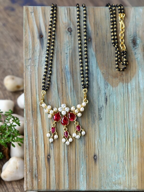 Red AD Draksha Tanmani Mangsutra necklace on wooden backdrop with pearls and beads