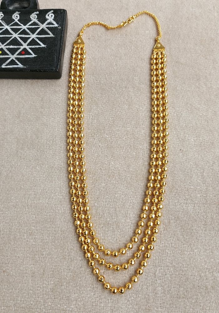 3-Strand Gold Bead Necklace on Neutral Background