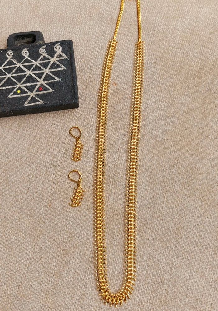 Traditional Gold Durva Haar Necklace 30 Inch
This image shows a gold-colored necklace with a traditional Indian design, known as a Durva Haar, alongside a patterned black pendant. The necklace appears to be approximately 30 inches long and made of intricate metalwork.