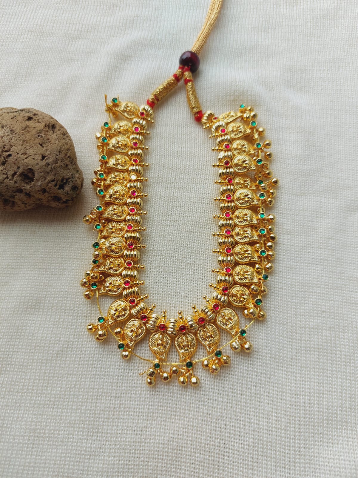 Ornate golden beaded necklace with pendant drops, traditional Kolhapuri design from Mugdha Jewellery Store.