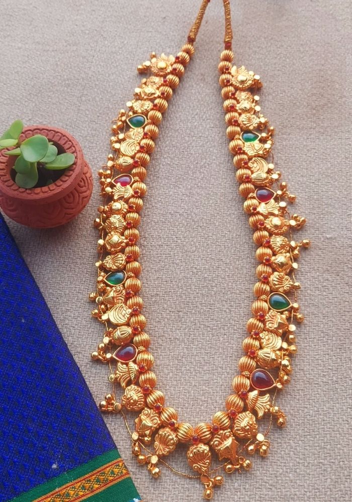 Geru Plated Kolhapuri Saaj - Vibrant gold-toned necklace with intricate floral motifs and colorful gemstones, displayed on a plain background.