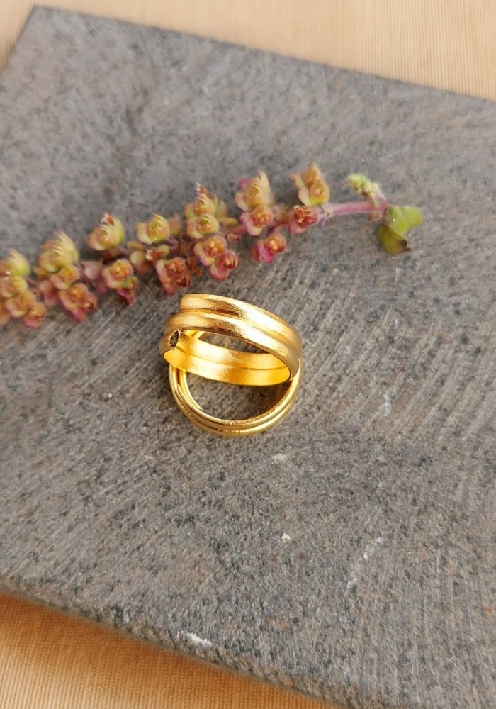 Traditional gold toe ring on a grey fabric background with colorful flowers