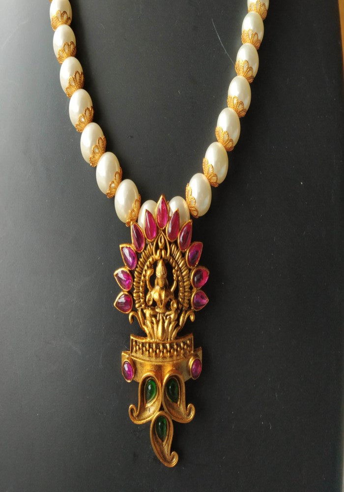 Intricate Goddess Laxmi Temple Jewellery pendant on a pearl necklace, showcasing the brand Mugdha Jewellery Store.
