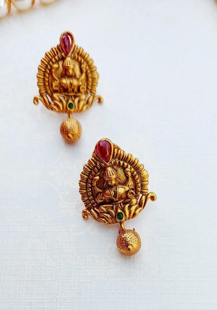 Exquisite golden Goddess Laxmi temple jewelry, featuring intricate designs and vibrant red accents, showcased on a plain white background.