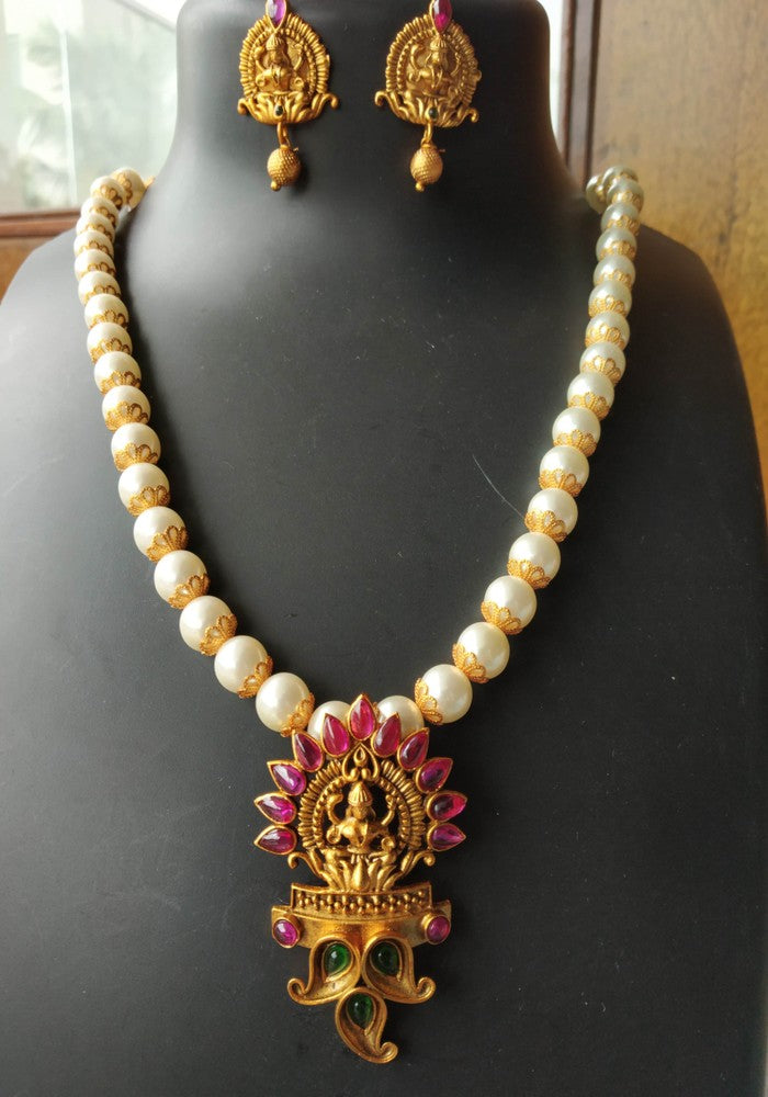 Elegant pearl necklace with golden Goddess Laxmi pendant and earrings, intricate Indian traditional jewelry from Mugdha Jewellery Store.