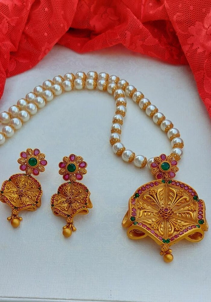 Peshwai Flower Temple Jewellery: Gold-plated flower-shaped pendant with vibrant gems, complemented by a pearl necklace from the Mugdha Jewellery Store.