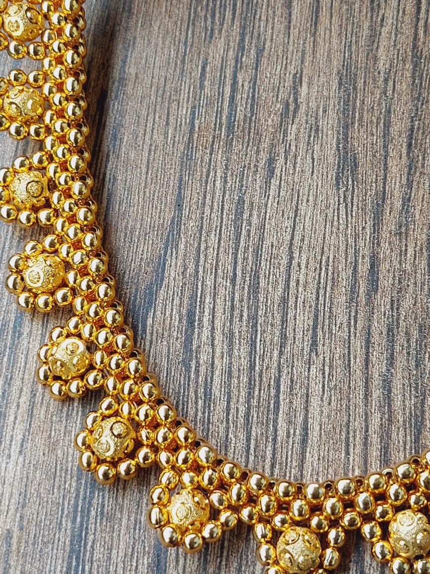 Gold Necklace on Wooden Surface
