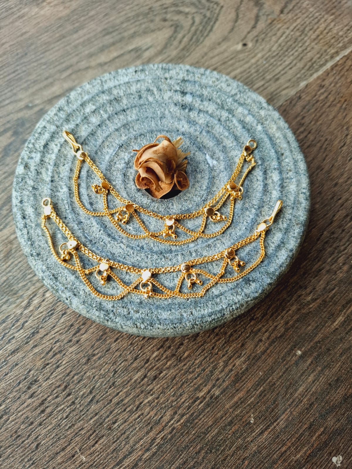 Designer Golden Ear Chain with delicate golden beaded accents on gray circular fabric background