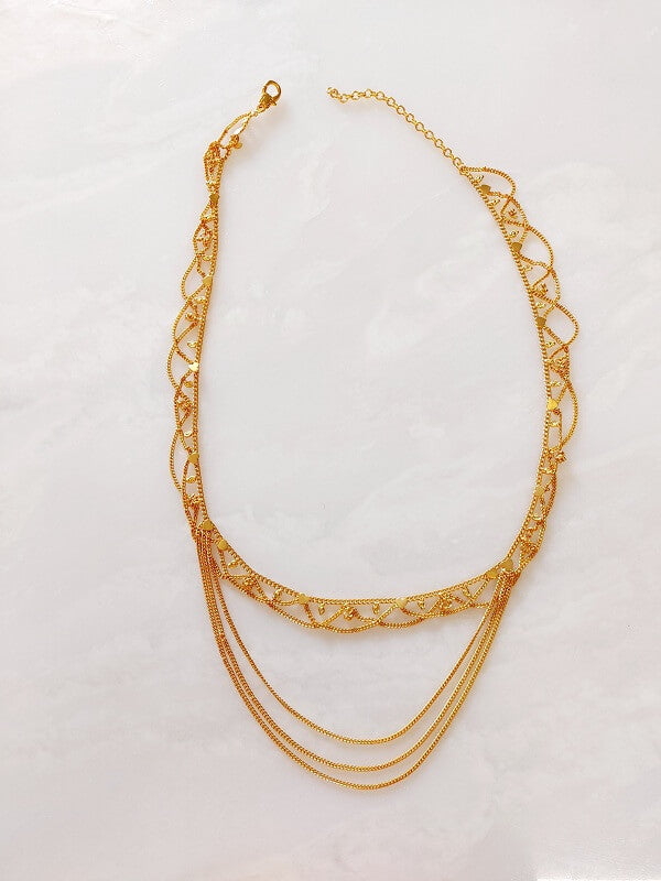 Elegant gold-toned waist belt with intricate filigree design and multiple chain strands, perfect for adding a touch of luxury to any outfit.