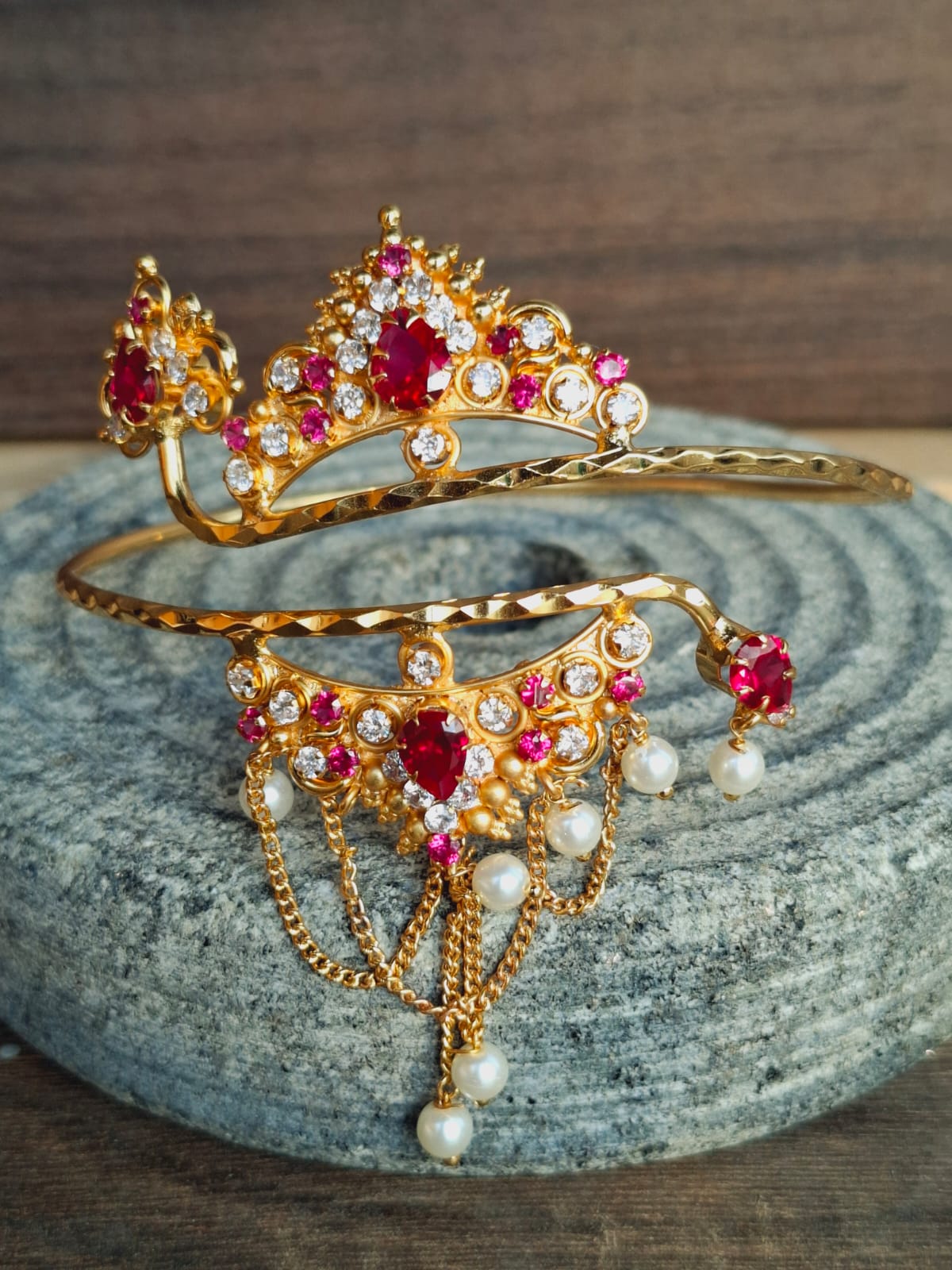 Radiant gold-toned bajuband adorned with vibrant red and white gemstones, creating an exquisite piece of Indian fine jewelry.