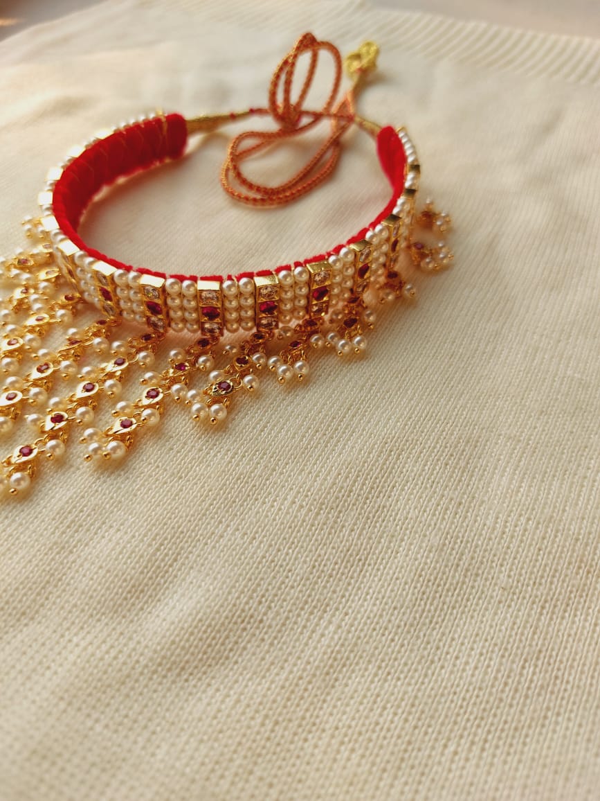 Dark Pink White 4 Patti Zhalar Gadi Chinchpeti - Ornate traditional jewelry piece with intricate red and golden beaded design, displayed on a white fabric surface.