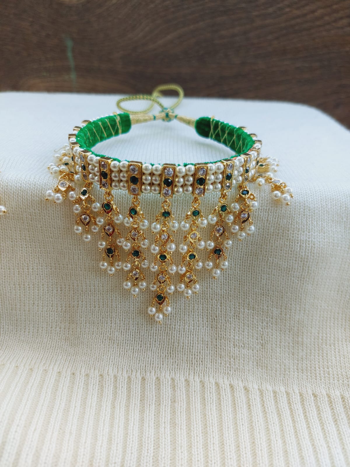 Ornate pearl and crystal embellished green woven bracelet from Mugdha Jewellery Store, featuring an intricate dangling design.