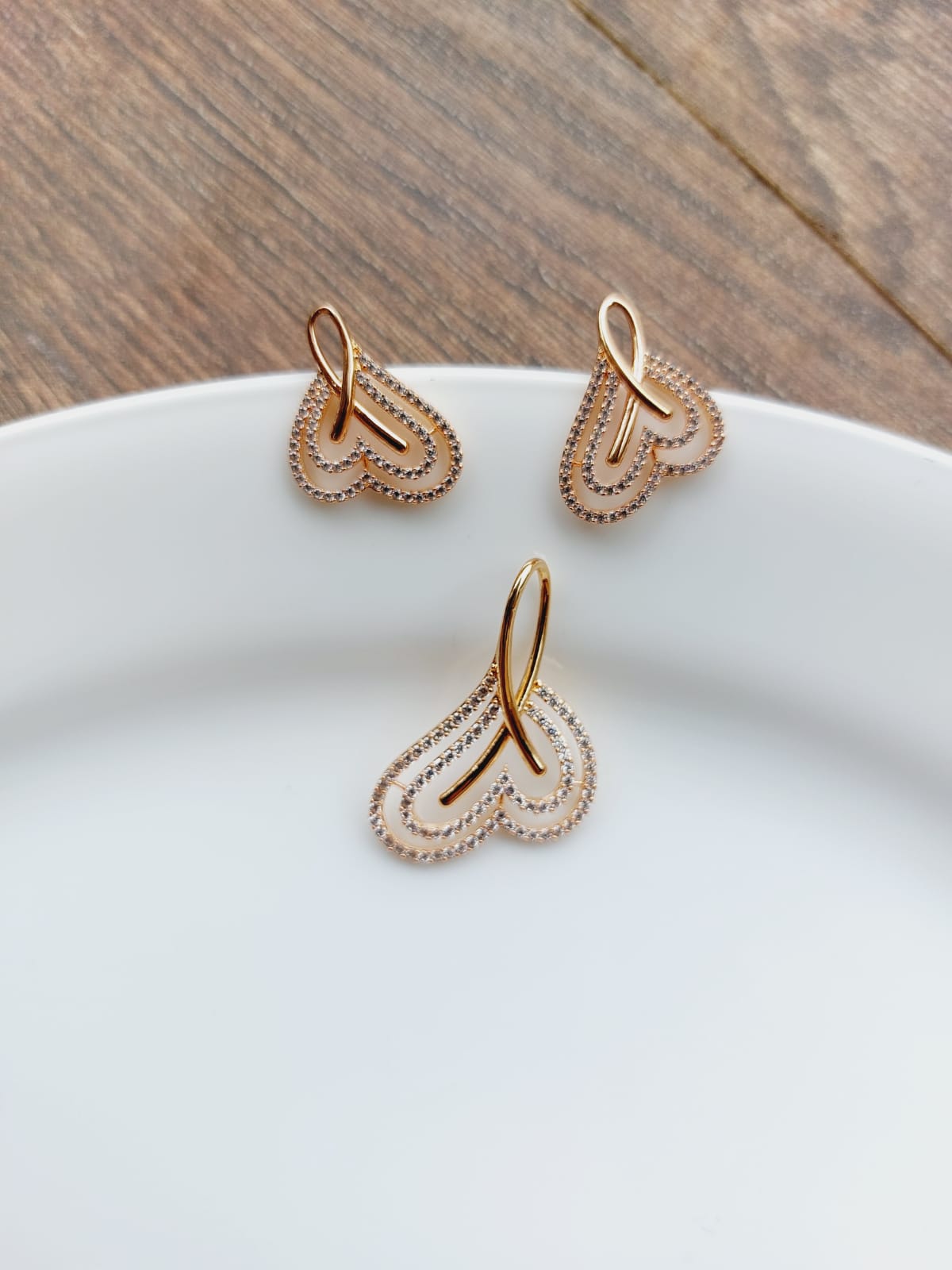 Rose Gold Plated American Diamond High Quality Heart Pendant Set featuring delicate heart-shaped pendants with sparkling American diamonds on a white plate.