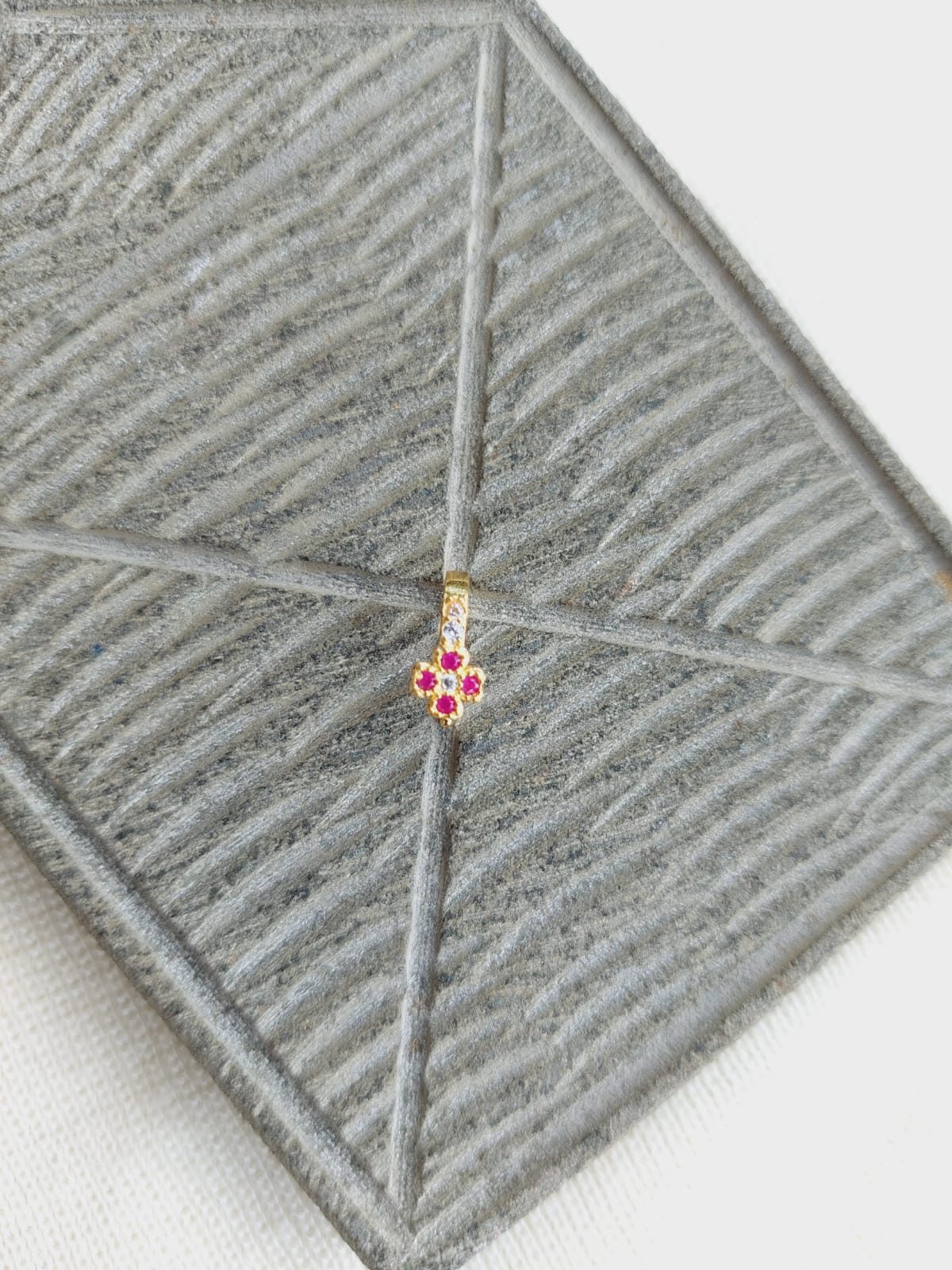Elegant Red Flower Nose Pin on Textured Gray Backdrop