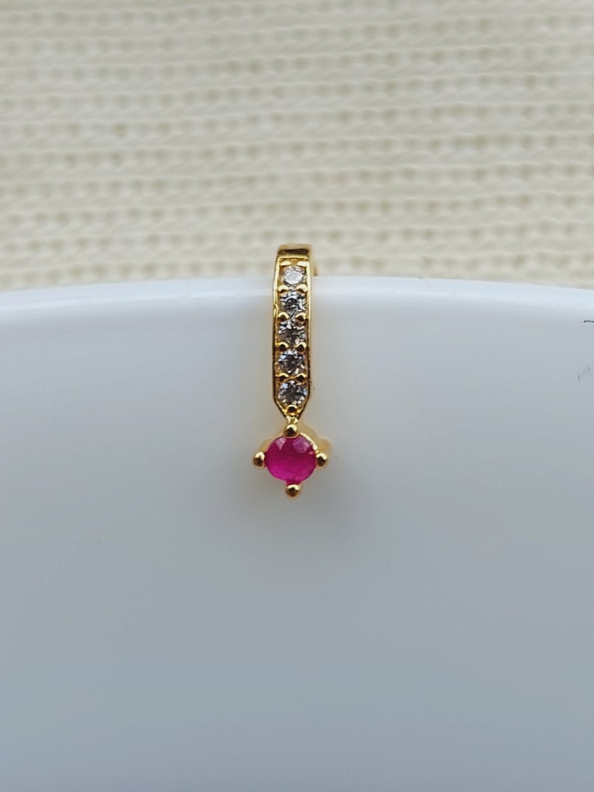 Elegant gold nose pin with sparkling ruby centerpiece and pave-set diamond accents