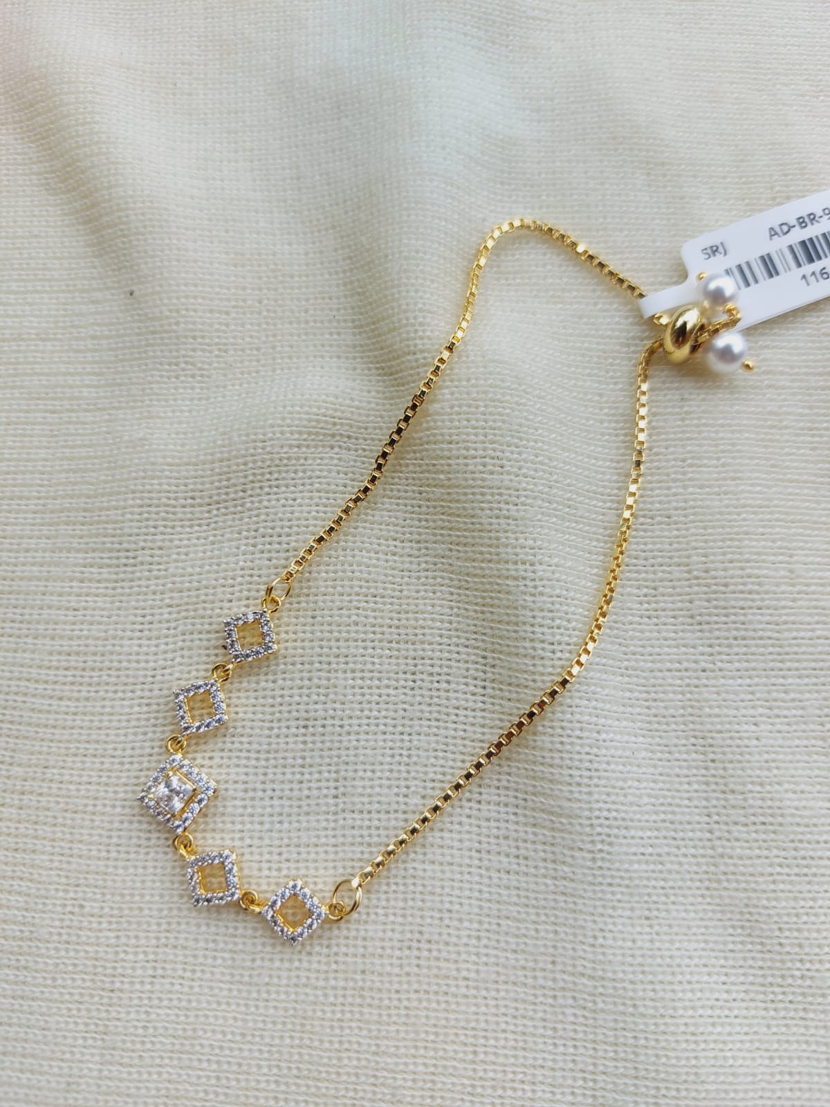 Beautiful Adjustable Diamond Bracelet - Gold-toned jewelry with delicate diamond accents displayed on a light fabric background.