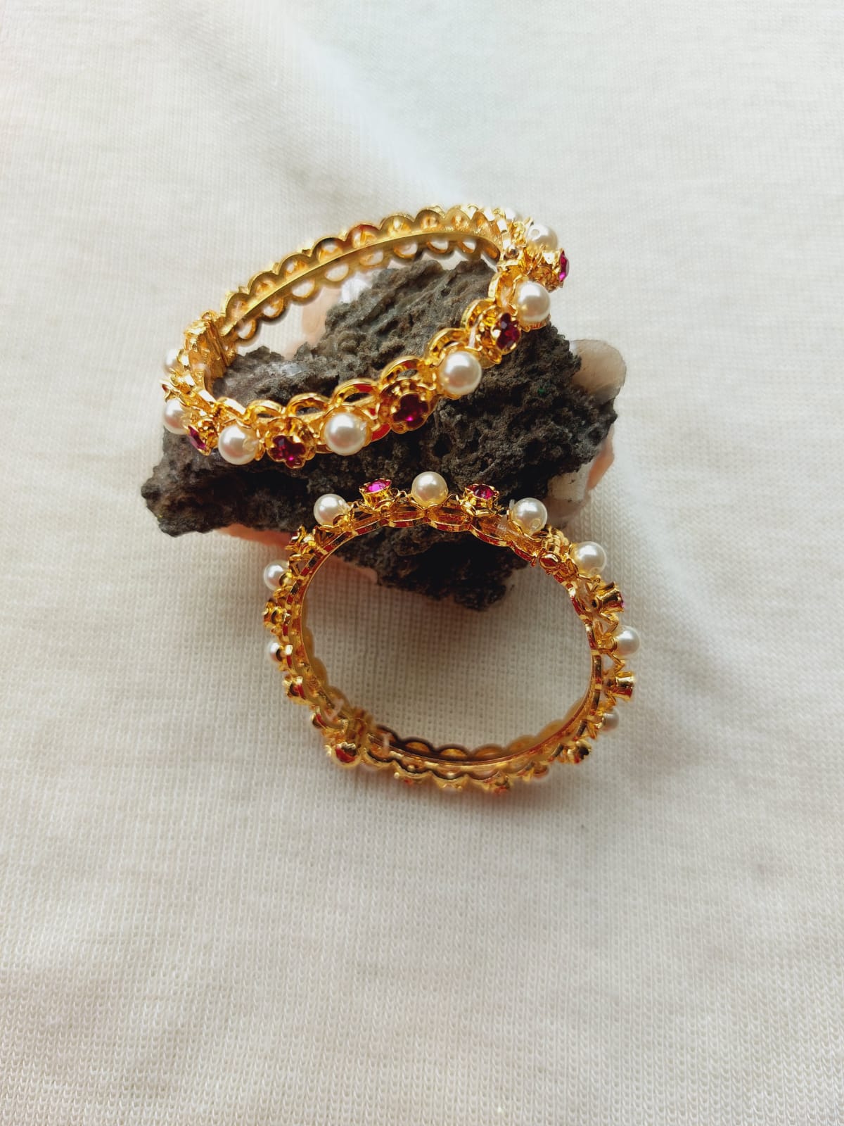 Elegant golden bangles with intricate beaded accents, showcasing a refined and sparkling jewelry design.