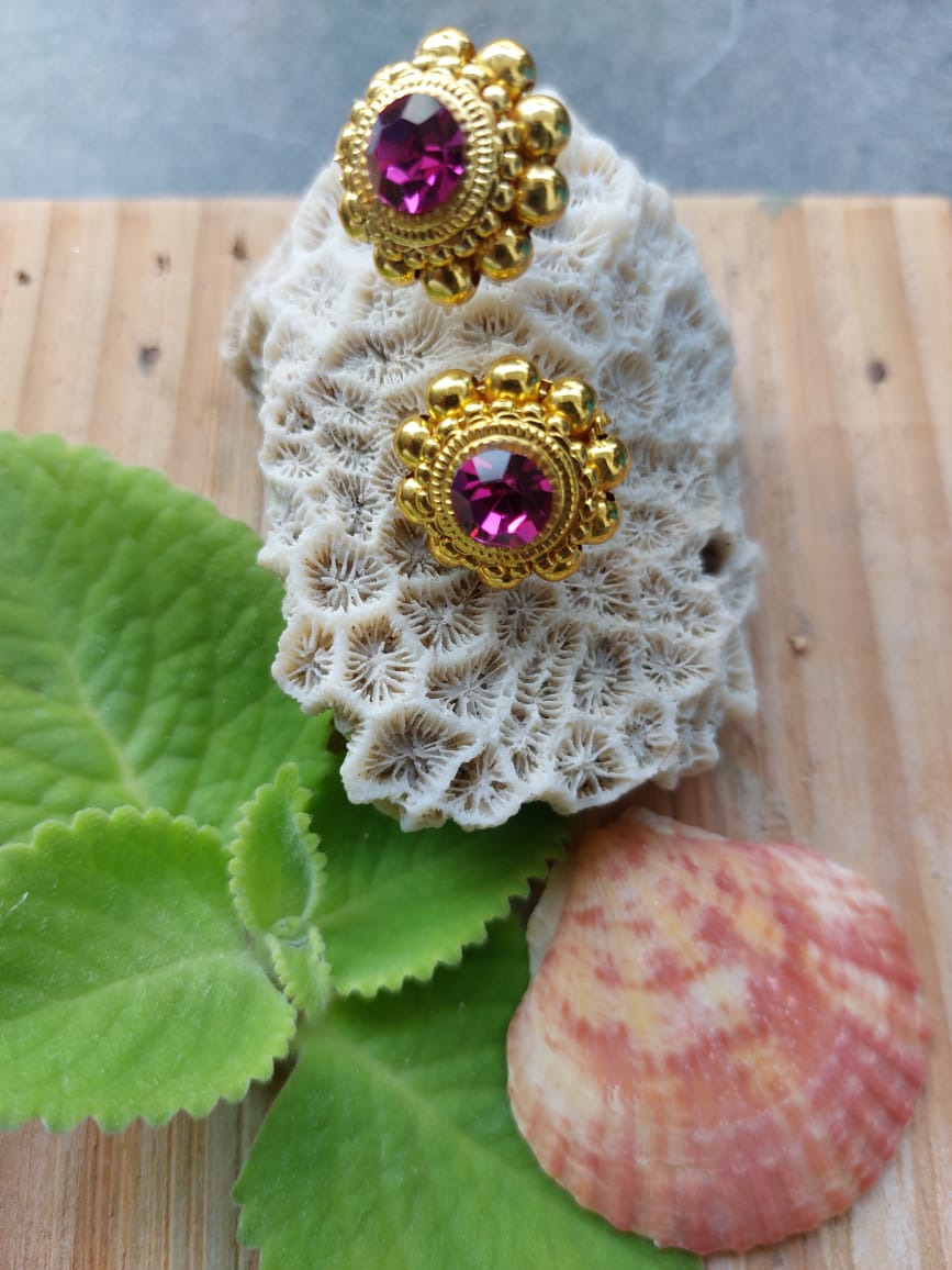 Ornate Gold-Toned Earrings with Amethyst Accents on White Crocheted Floral Background