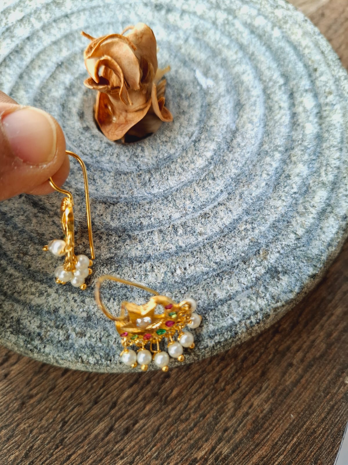 Multicoloured star-shaped chandrakor bugdi with pearl beaded earrings on grey abstract background from Mugdha Jewellery Store.