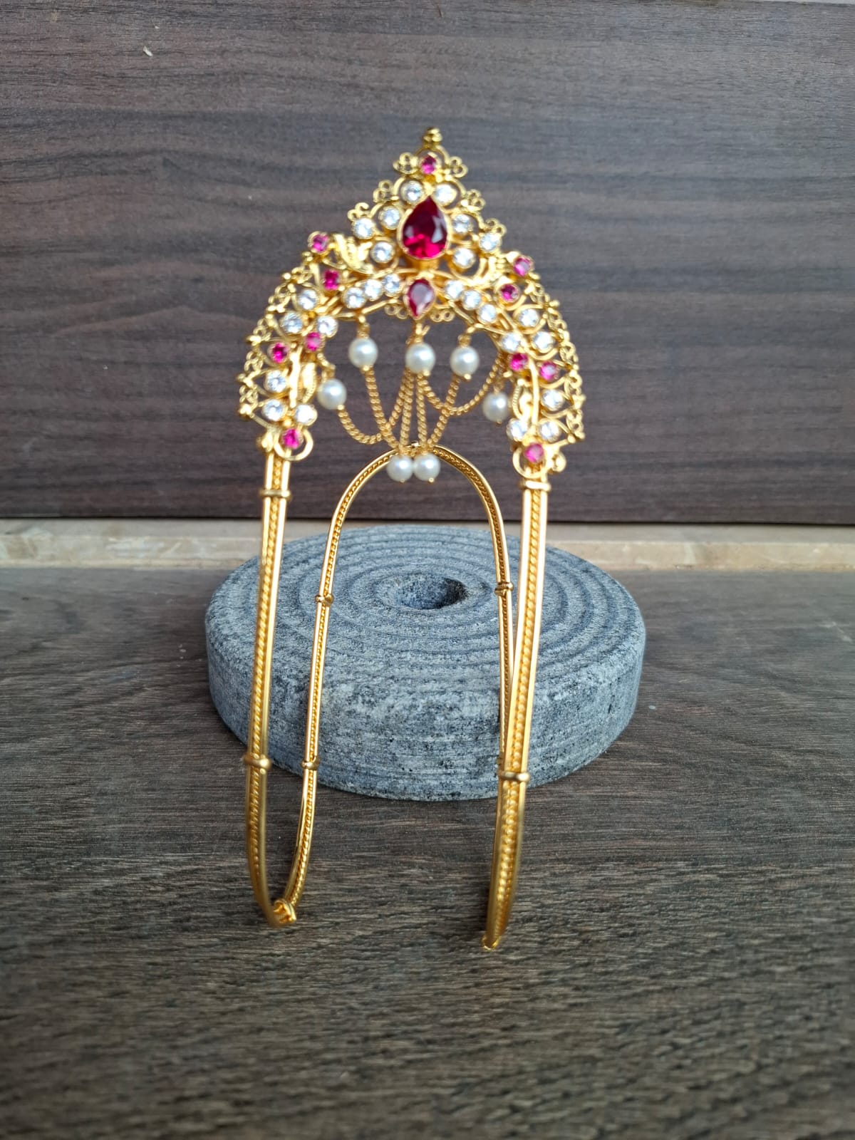 Exquisite Mhalsa Bajuband: Ornate gold-tone jewelry piece adorned with vibrant red and white gemstones, presented on a grey fabric backdrop.