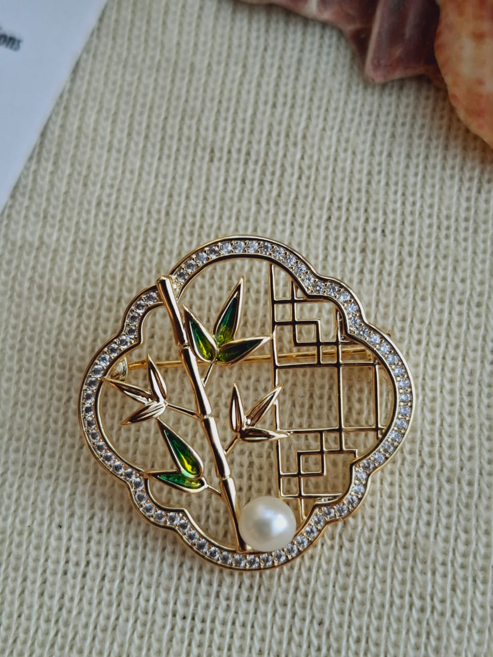 Nature-inspired Bamboo Design Saree Pin with Rhinestones and Pearl Accent, Featured on Beige Textile