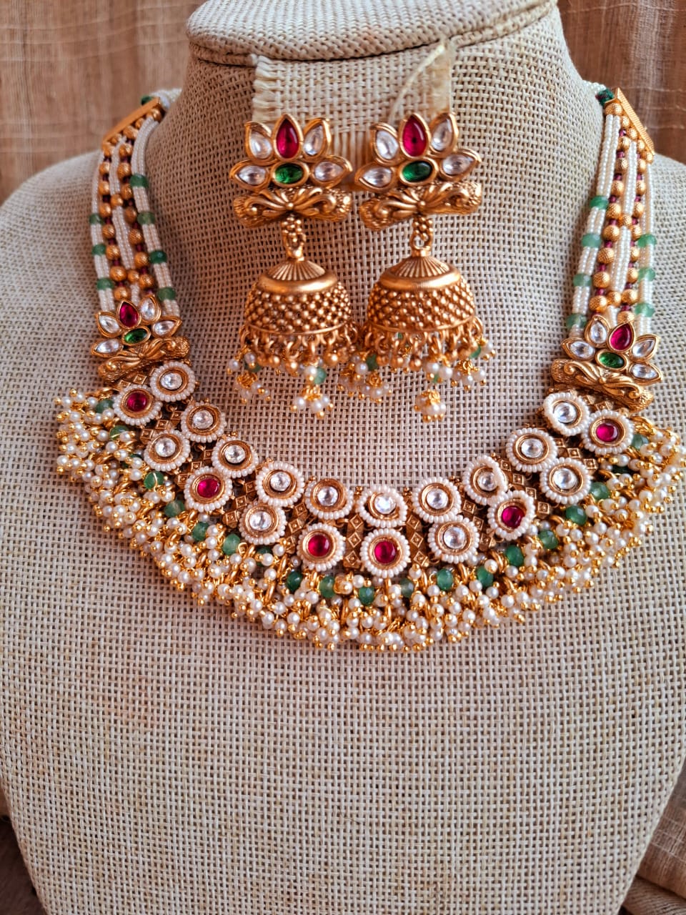 Ornate gold-tone royal necklace with intricate gemstone detailing, showcasing traditional Indian jewelry craftsmanship from the Mugdha Jewellery Store.