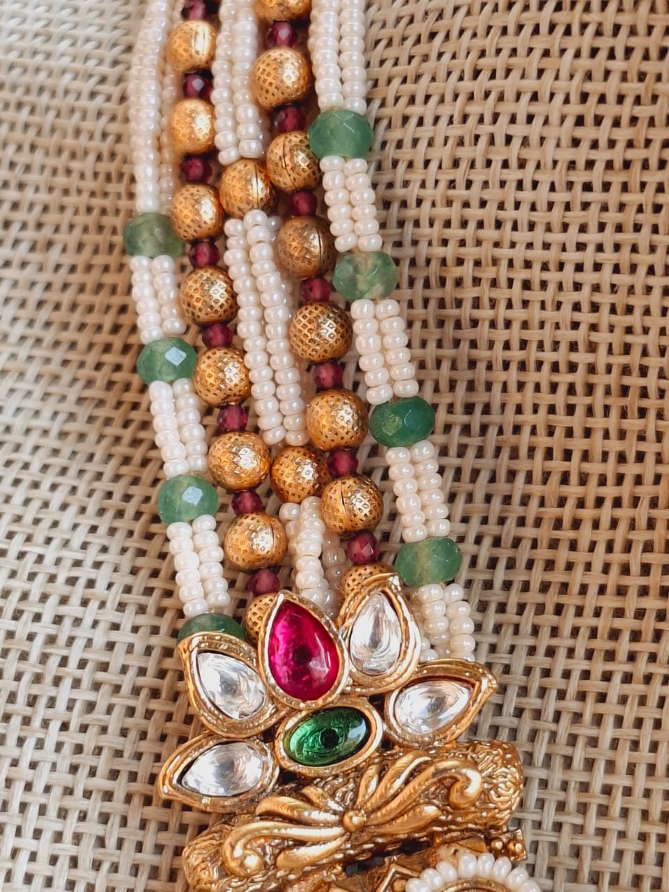 Elegant Maharani Padmawati Royal Necklace from Mugdha Jewellery Store. Ornate gold-toned floral design with vibrant multicolored gemstones and pearls. Intricate craftsmanship on display.