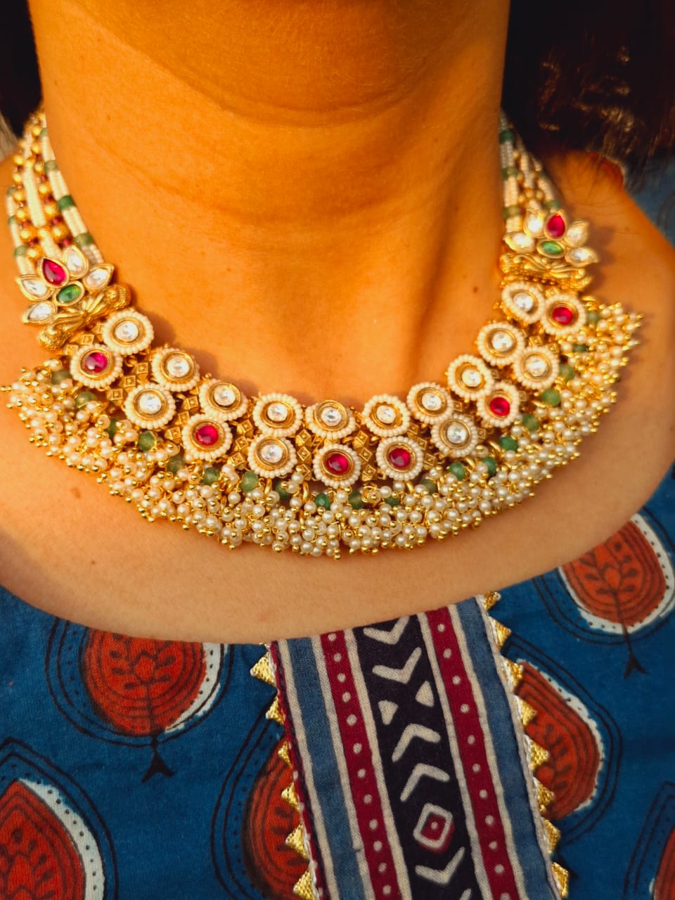 Magnificent gold and ruby-encrusted Maharani Padmawati Royal Necklace displayed on a traditional ethnic patterned cloth.