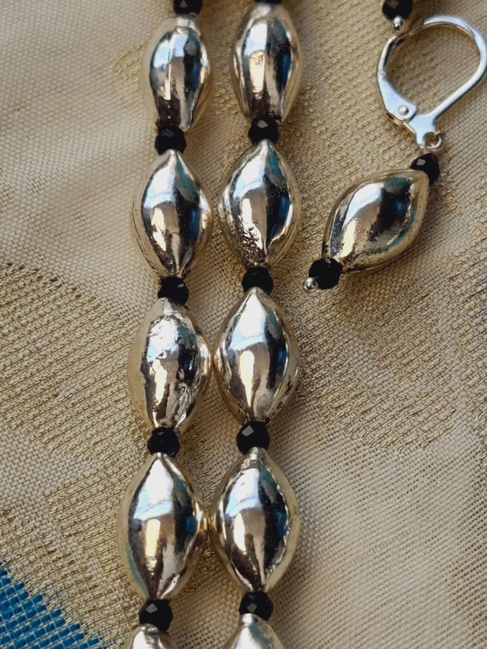 Sleek oxidized metal lyre-shaped beads on a long necklace from Mugdha Jewellery Store