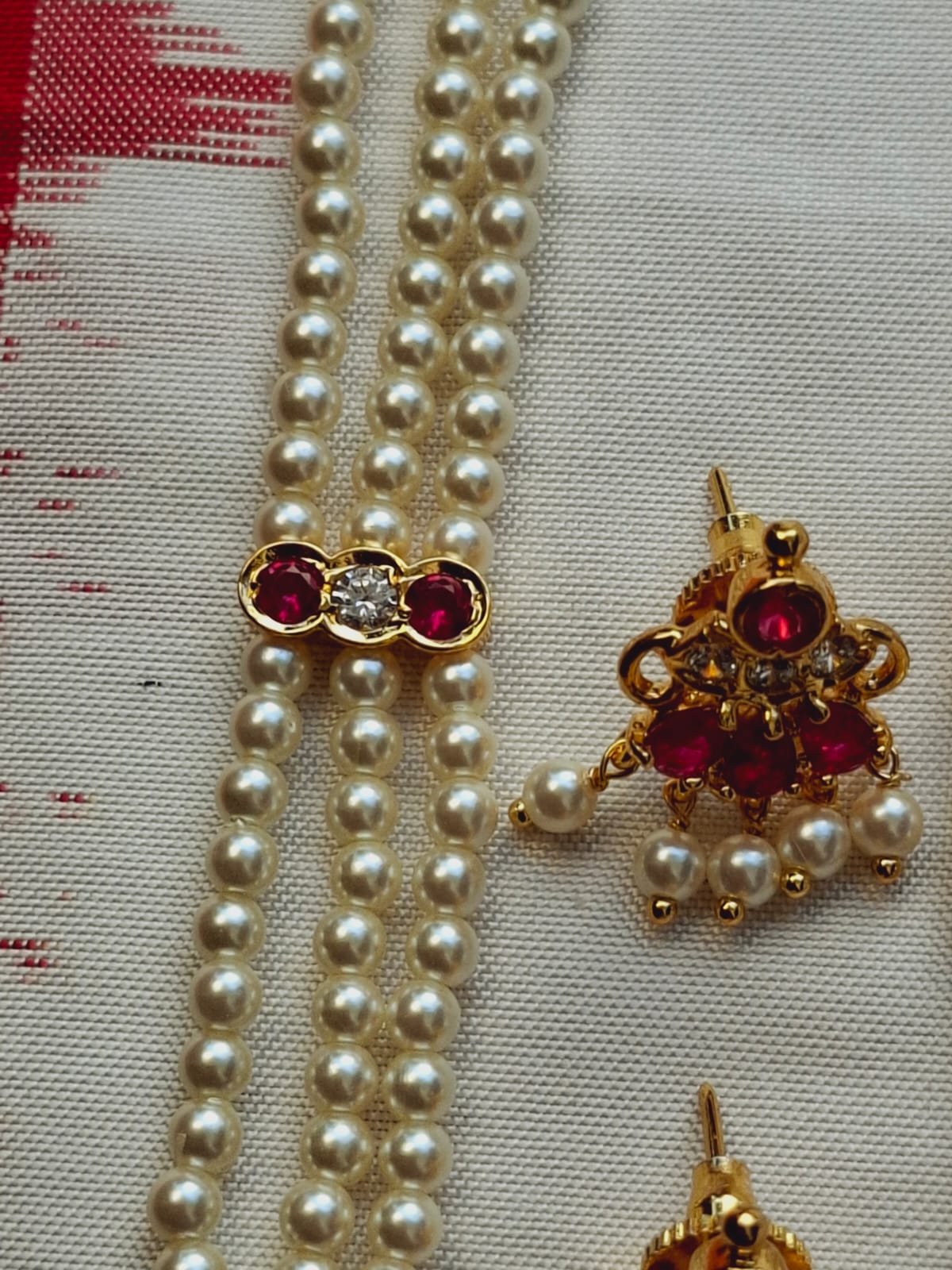 Elegant pearl necklace with ruby-colored gemstone pendants from the Mugdha Jewellery Store collection.