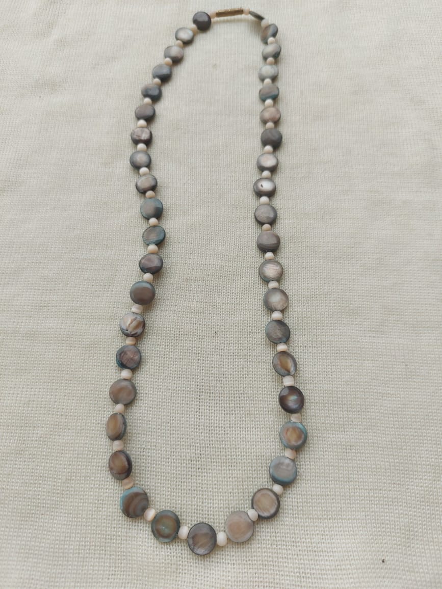 Elegant shell necklace featuring natural-hued beads strung together in a stylish design, creating a unique and beautiful accessory.