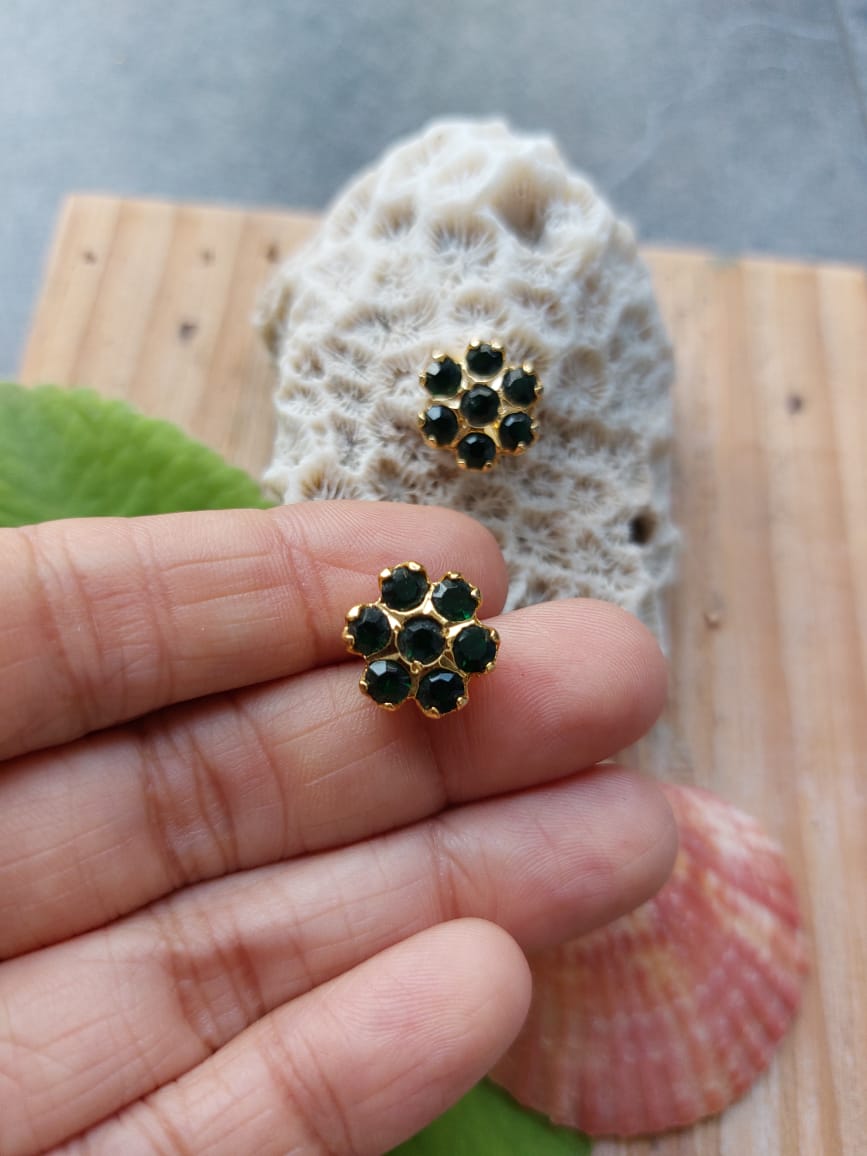 Green Stone Kudi Earrings by Mugdha Jewellery Store - Elegant gemstone studs displayed on a natural seashell backdrop.