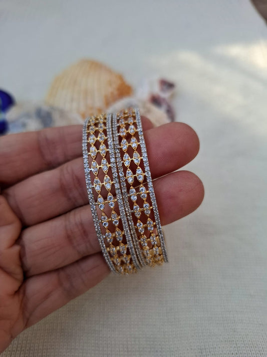 Stunning set of 2 American diamond designer bangles in gold and silver tones, featuring intricate floral patterns and sparkling crystal accents. Size: 2 by 4 inches.