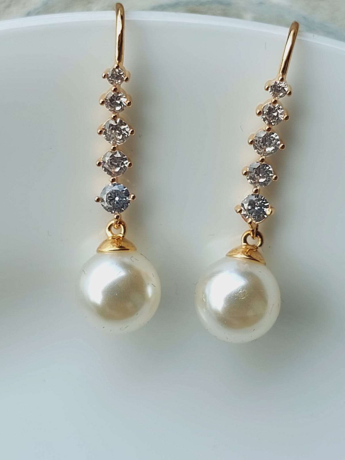 Elegant pearl and crystal dangler earrings from the Mugdha Jewellery Store collection, featuring a row of sparkling crystals and a lustrous pearl drop.