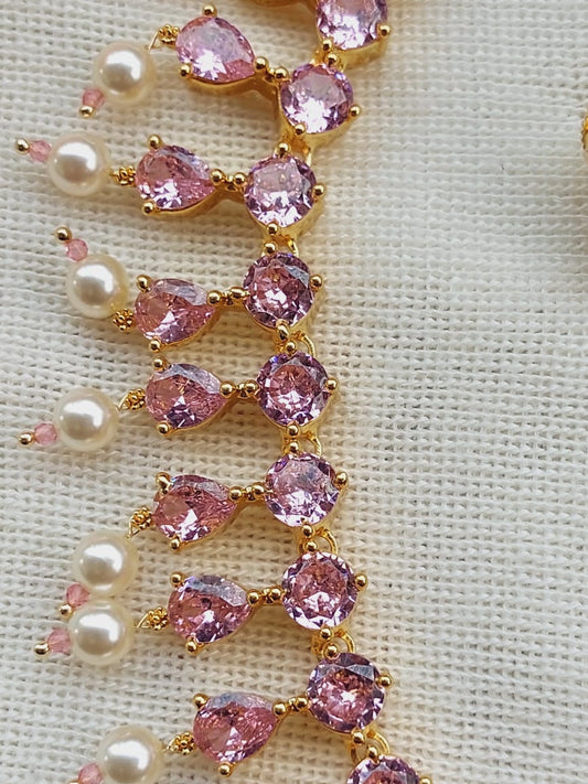 Elegant gold-tone necklace adorned with light pink gemstones and lustrous pearls, showcasing a stunning jewelry design.