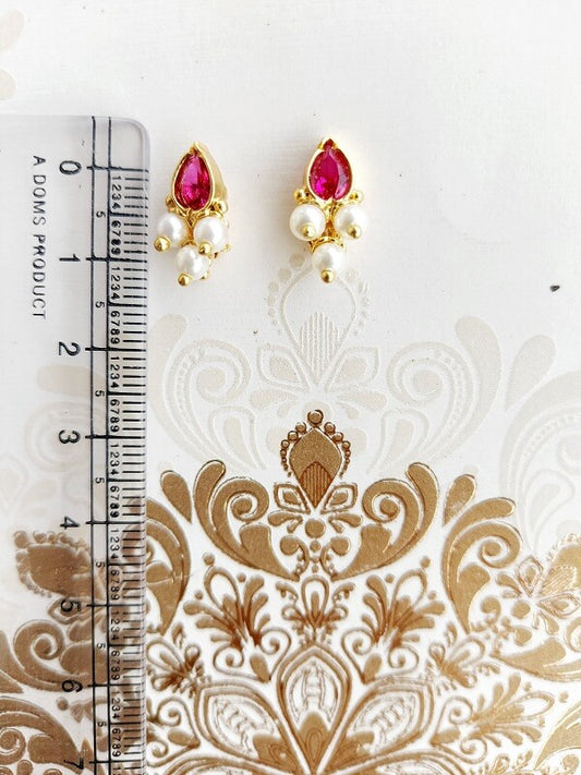 Pink Stone Karwwari Draksha Small Earrings by Mugdha Jewellery Store - Captivating gold-tone teardrop-shaped earrings with intricate floral embellishments, vibrant pink stones, and lustrous pearls.