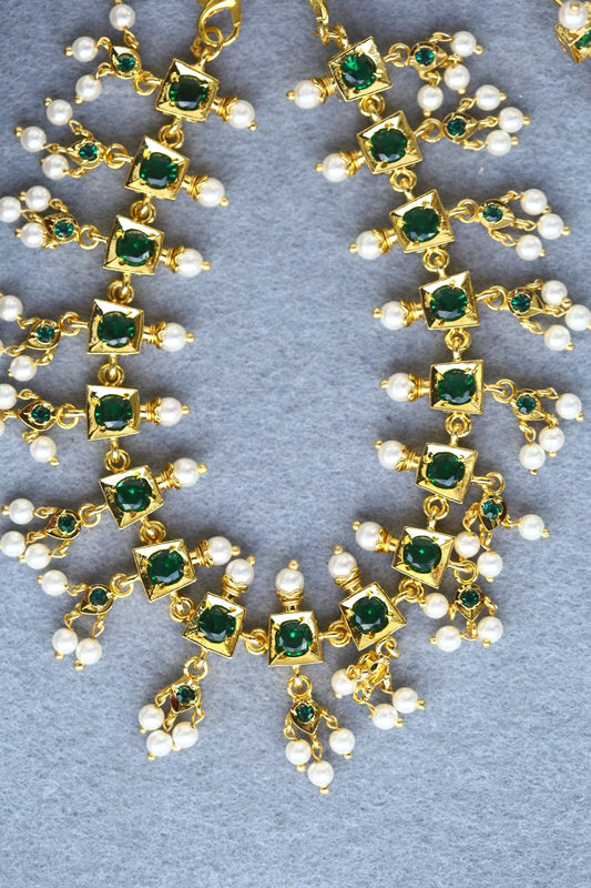 Beautiful Green Traditional Designer Set

This image shows a pair of ornate gold-toned jewelry pieces, likely earrings or a necklace, adorned with green gemstones and white pearls arranged in a floral pattern. The intricate design and use of contrasting colors and materials create a visually stunning traditional jewelry set.